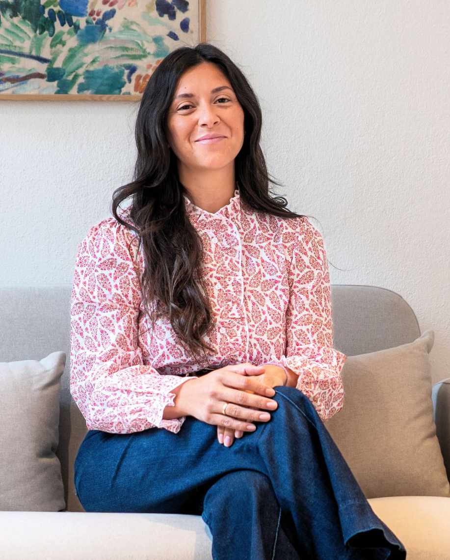 Melissa Spiegl Guerrero sitzt auf der Couch in ihrem Praxisraum