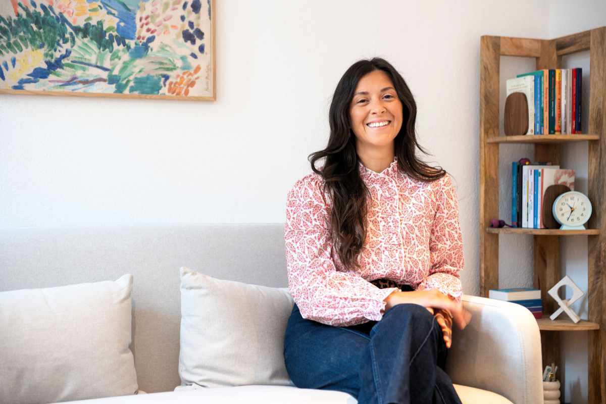 Melissa Spiegl-Guerrero sitzt auf einer hellen Couch in ihrer Praxis für Psychotherapie in Innsbruck